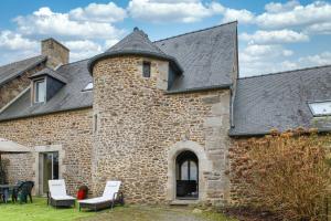 塔登Tour des Alleux - Maison de maître pour 6的一座老砖砌建筑,在院子里设有白色椅子