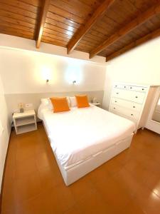罗列特海岸Private Apartments Cala Canyelles的客房内的白色床和两个橙色枕头