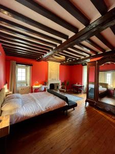 Ver-sur-MerLe Nouveau Port的一间大卧室,拥有红色的墙壁和一张大床