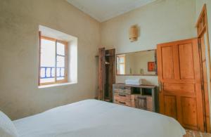 索维拉Stella 1 - joli appartement en médina avec cheminée的一间卧室配有床、水槽和镜子