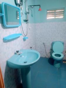 锡吉里亚Sigiriya Guest House Inamaluwa的浴室配有蓝色水槽和卫生间。