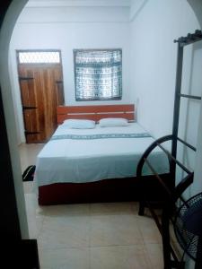 锡吉里亚Sigiriya Guest House Inamaluwa的一间卧室设有一张床和一个窗口