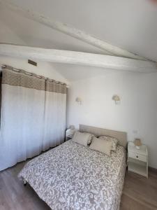 艾格-莫尔特Le Repaire du Soleil的一间白色的卧室,配有床和窗帘