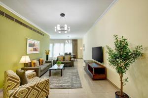 迪拜Radiance Premium Suites的客厅配有两张沙发和一台电视机