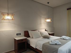 莫奈姆瓦夏莫奈姆瓦夏之花酒店的卧室内的两张床,墙上有两盏灯