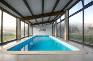 FriolHotel Rural O Cruce do Burgo的一座带大窗户的别墅内的游泳池