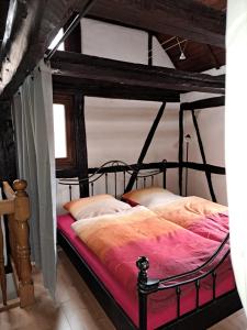 布罗特罗德Ferienwohnung Gesindestube的一间卧室配有一张带黑色铁床架的床