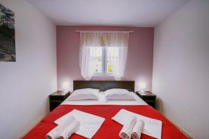 默主歌耶Villa Marinko的一间卧室配有一张红色的床和两对袜子