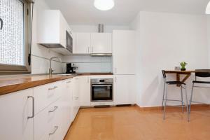 罗萨里奥港Casa Rosi 2的白色的厨房配有白色的橱柜和桌子