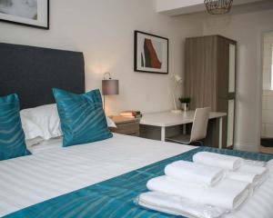 斯旺西Luxe Living Guest House-Sleeps 6 -Family Friendly-Private Parking-Wifi-City-Beach的酒店客房,配有带毛巾的床