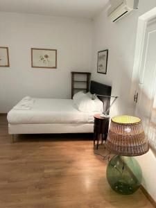 佛罗伦萨Lungarno Vespucci Florence Studio的一间卧室配有一张床、一张桌子和一盏灯