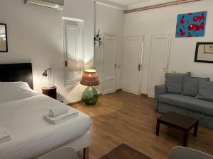 佛罗伦萨Lungarno Vespucci Florence Studio的客厅配有床和沙发