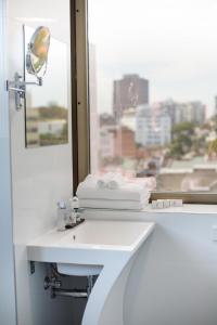 悉尼57号酒店的一间带白色水槽和窗户的浴室