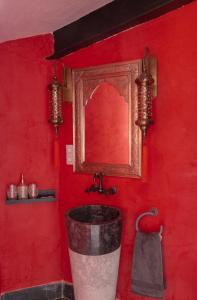 托莱多RIAD MEDINA MUDEJAR BAÑOS ARABES的红色的浴室,配有水桶和镜子