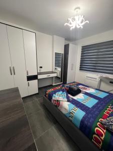 拉赫姆Dolce Italia Residence的一间卧室配有一张床、白色橱柜和吊灯。
