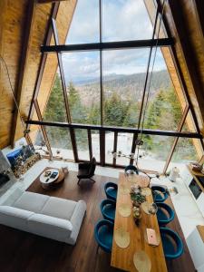 科帕奥尼克Sofia - Mountain Home的客厅设有桌子和大窗户