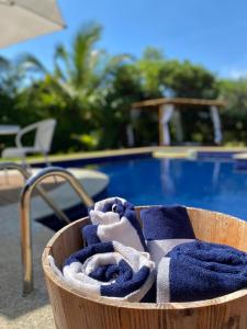 科斯塔萨乌佩Costa do Sauipe Casa dentro do complexo hoteleiro的游泳池旁一个装满蓝色毛巾的篮子