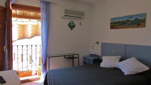 昆卡德拉路孜旅馆的一间卧室设有一张床和一个大窗户