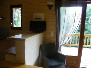 Saint-MaxireLe Chalet du Chloris的小屋内的房间配有书桌和电视
