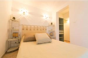 圣弗洛朗Appartement T2 rez de villa的卧室配有一张带两盏灯的墙壁床。