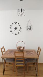 Donje MladiceApartman Stan ,Istocno Sarajevo 26的一张桌子、两把椅子和墙上的时钟