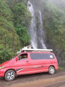 亚的斯亚贝巴King Dawit Ethiopia Tours & Travel的停在瀑布前的一辆红色货车
