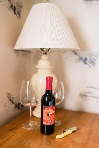 GlenwoodFox & Bear Lodge的一张桌子上放着一瓶葡萄酒,放上两杯