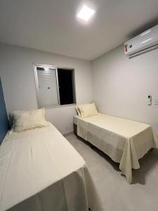 戈亚尼亚Lindo apartamento no Setor Bueno- todo reformado - tudo novinho -Sua busca termina aqui的客房设有两张床和窗户。