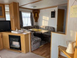 赫姆斯比the Samanda Van Newport caravan park的客厅配有沙发和大篷车内的桌子