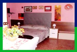巴勒莫圣奥利瓦民宿的一间卧室配有一张床和一张鲜花桌