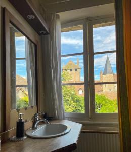 欧坦Maison Sainte Barbe的浴室水槽和享有城堡景致的窗户。