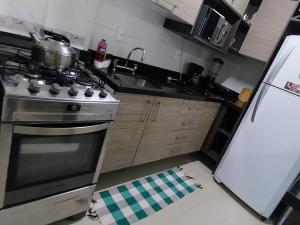 卡庞达卡诺阿Espaçoso aconchegante的厨房配有炉灶和冰箱。