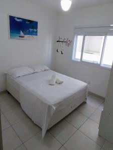 卡庞达卡诺阿Espaçoso aconchegante的白色的卧室设有床和窗户