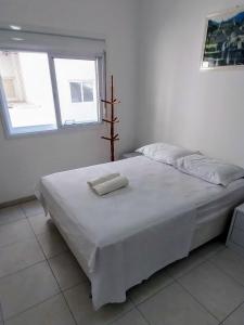 卡庞达卡诺阿Espaçoso aconchegante的窗户客房内的一张白色床