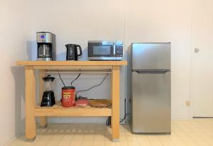 拉瓦尔Montreal - Laval Haven - Entire rental unit的厨房配有带微波炉和冰箱的桌子