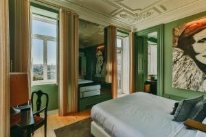 波尔图托雷尔前卫酒店的一间卧室设有绿色的墙壁和一张带绘画的床