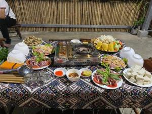 高平Minh Khang Homestay - Làng đá cổ Khuổi Ky的餐桌上放有食物盘子的桌子