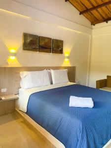 伯里塔卡Senderos del Mar的一间卧室配有一张带蓝色毯子的大床