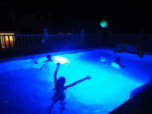 阿尔豪林德拉托里Villa Paraiso - Appartement 2 pièces privatif的2名儿童在晚上在游泳池玩耍
