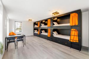 维也纳Stadtaffe - Chic Hostel VIE的客房设有双层床、书桌和桌子。