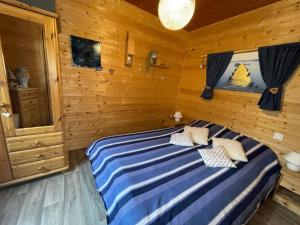 MontminSuperbe T3 neuf en bord de rivière près d'Annecy的木制客房内的一间卧室,配有一张床