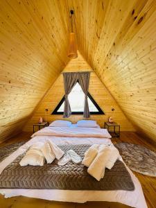 卡兹贝吉mood villa Kazbegi的木制客房内的一张大床,设有窗户