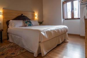 欧罗尔O Viso Ecovillage - Hotel Ecologico Vegano的一间卧室配有一张大床和木制床头板