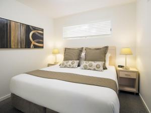 MiddlemountOaks Middlemount Suites的一间卧室配有一张带两盏灯的大型白色床。