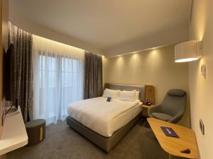 安卡拉Holiday Inn Express - Ankara - Airport, an IHG Hotel的酒店客房配有一张床、一张桌子和一把椅子。