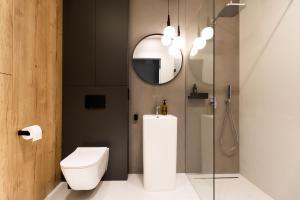 格丁尼亚Apartament Plac Unii的浴室设有卫生间和带镜子的淋浴
