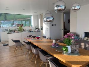 阿特湖畔努斯多夫Attersee Luxury Design Villa with dream views, large Pool and Sauna的用餐室以及带长桌子和椅子的厨房