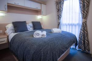安姆罗斯Ty Moselle 12 - 2 Bedroom Holiday Home - Amroth的一间卧室配有一张大床和毛巾