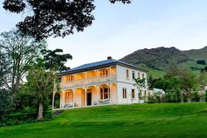 阿卡罗阿安南戴尔海边避世农庄及精选豪华别墅和度假屋的一座绿草丛生的山丘上的大型白色房屋