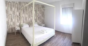 阿尔奇多纳Casa Rural - Santo Domingo Rural的卧室配有白色的天蓬床,铺有木地板